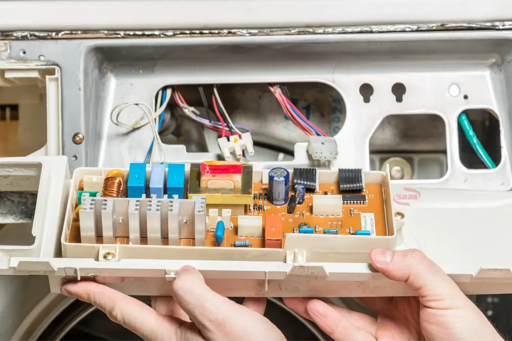 Kỹ thuật viên Minh Dương đang sửa bo mạch máy giặt Inverter