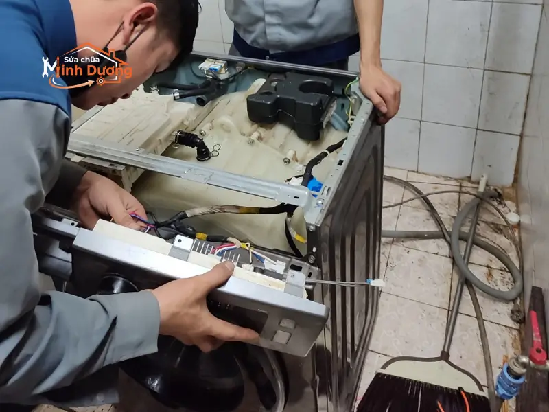Cận cảnh đôi tay đeo găng tĩnh điện của thợ giỏi Minh Dương Fix đang sửa bo mạch Inverter máy giặt LG lồng ngang bằng kính hiển vi và thiết bị đo mạch kỹ thuật số.