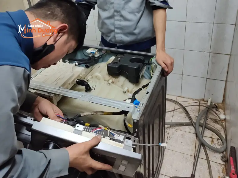 Kỹ thuật viên đo kiểm linh kiện IC cấp nước trên bo mạch máy giặt