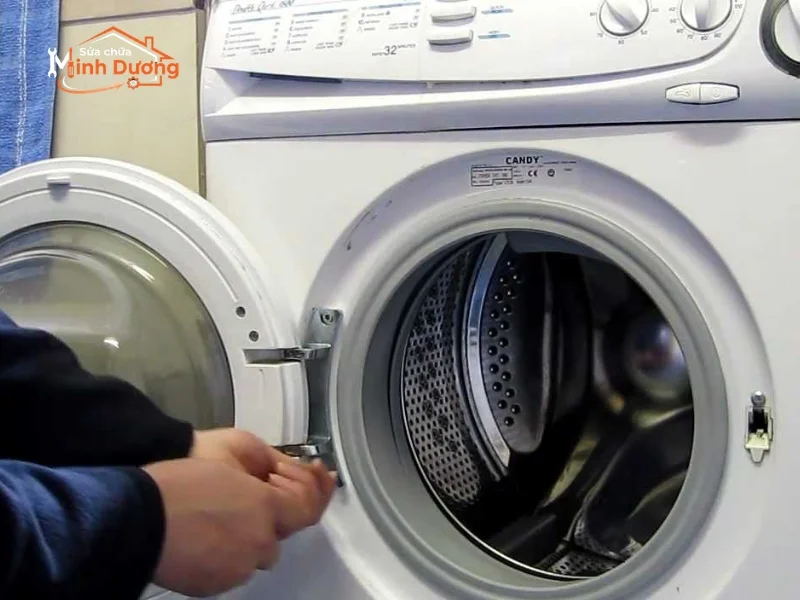 Thợ kỹ thuật đang nhấc bổng lồng inox ra khỏi vỏ máy tại Giảng Võ