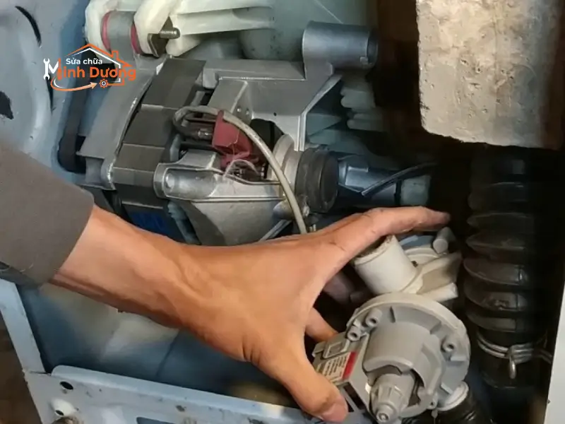 Kỹ thuật viên đang thay thế cụm bơm xả máy giặt chính hãng tại khu vực Hà Nội.