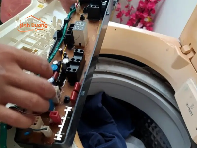 Kỹ thuật viên xử lý mạch màng than phím bấm máy giặt bị chạm chập do nồm ẩm