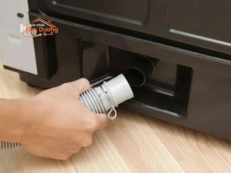 Hướng dẫn dùng đèn pin rà soát ống xả ruột gà phía sau máy giặt