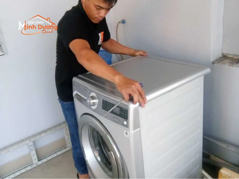 Thợ cơ điện lạnh khoan tường đấu nối dây tiếp địa máy giặt