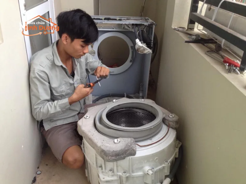 Thợ sửa chữa thay thế đồng bộ bộ giảm xóc thụt máy giặt
